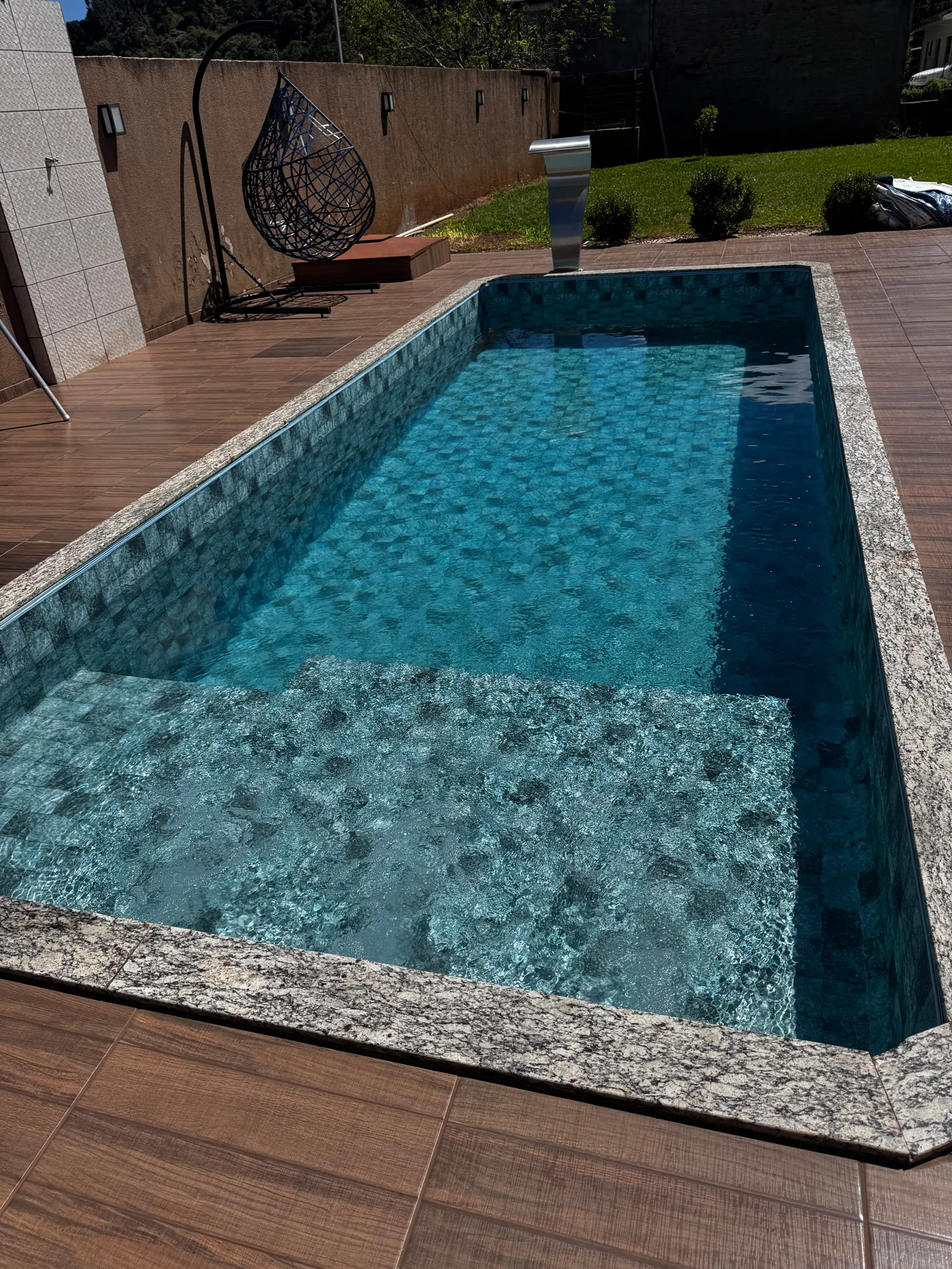 Piscina revestida com pastilha azul e borda de granito, feita pela Renove Piscinas em Pato Branco